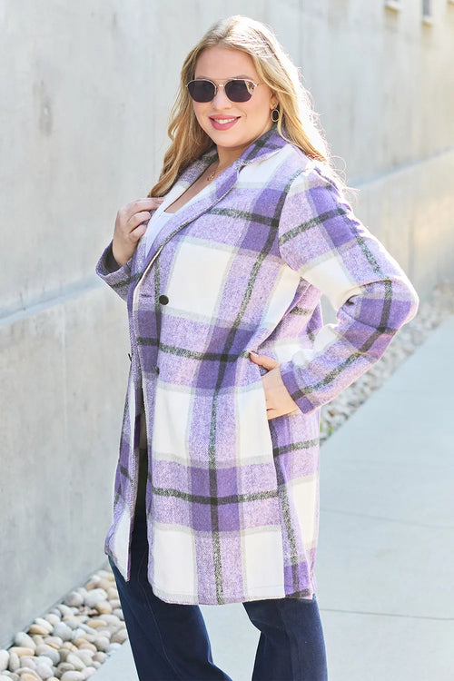 Woman wearing a purple and white plaid coat against a light background
