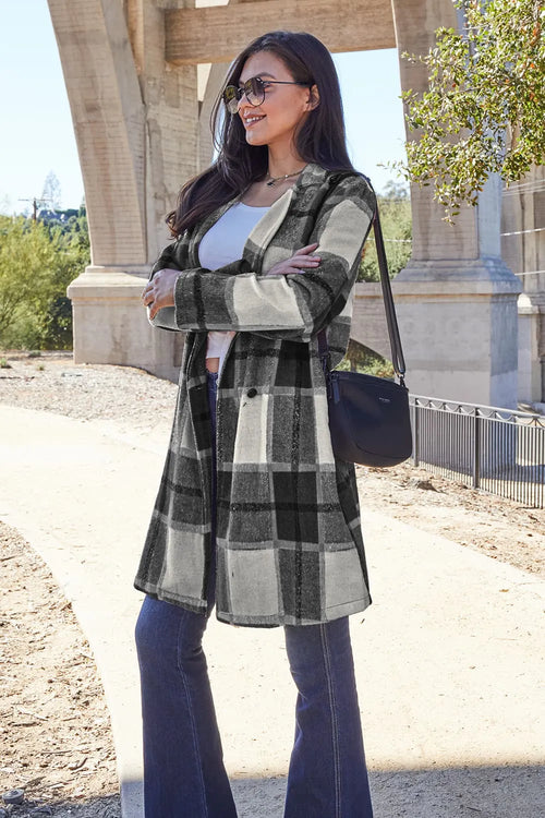 Woman wearing a plaid coat and sunglasses outdoors