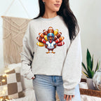 Person wearing a gray sweatshirt with a colorful turkey graphic in a cozy indoor setting