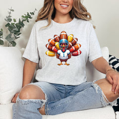 Person wearing a white t-shirt with a colorful graphic design sitting on a couch.