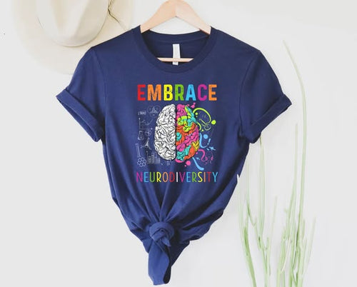 Graphic tee featuring a brain where one side is white anatomical lines and the other is a colorful explosion of musical notes, paint splatters, and symbols.