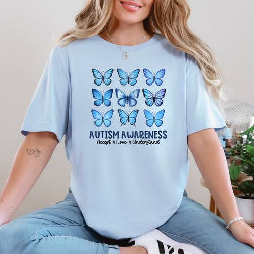 Graphic tee showing three rows of three blue butterflies with text below reading Autism Awareness Accept Love Understand.