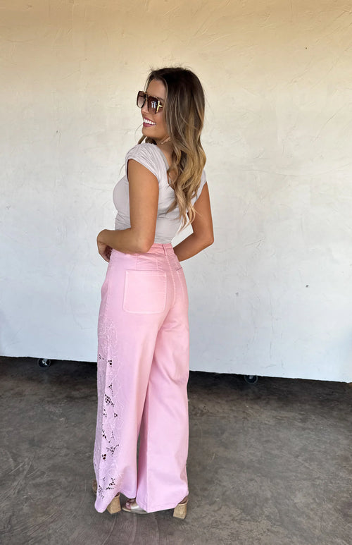Back view of the pink wide-leg jeans showing the flattering high-rise fit and clean hem.