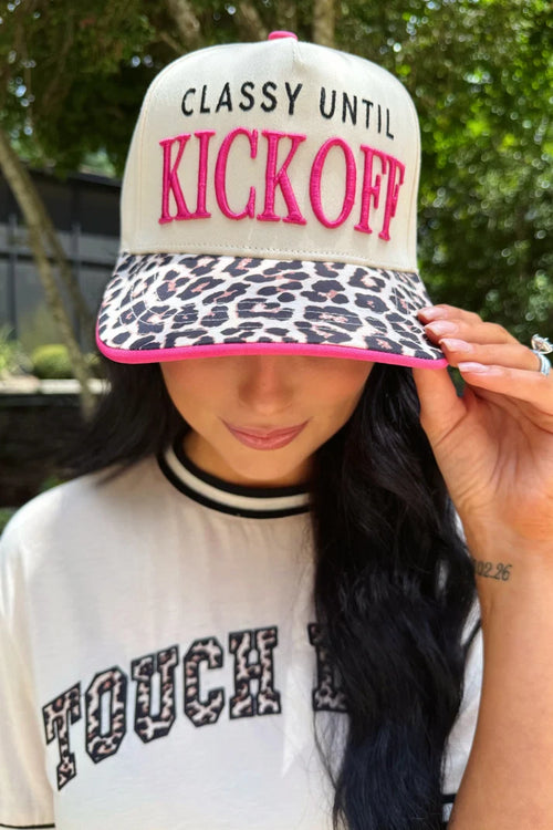 Person wearing a cap with 'Classy Until Kickoff' text and leopard print design.