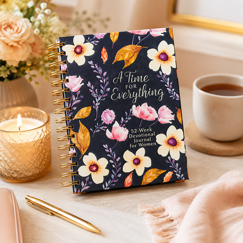 Floral notebook titled 'A Time for Everything' on a table with a cup of coffee, candle, and pen.