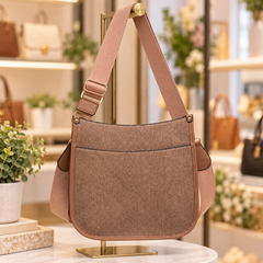 Brown denim crossbody bag displayed on a boutique purse rack