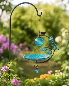 Decorative garden ornament with butterfly design and glass elements in a garden setting.