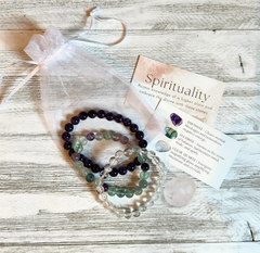Set of beaded bracelets with a card on a wooden surface