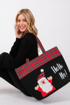 Woman holding a Christmas-themed tote bag with Santa Claus and 'Ho Ho Ho!' text.