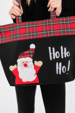 Tote bag with Santa Claus design and 'Ho Ho Ho!' text, held by a person.