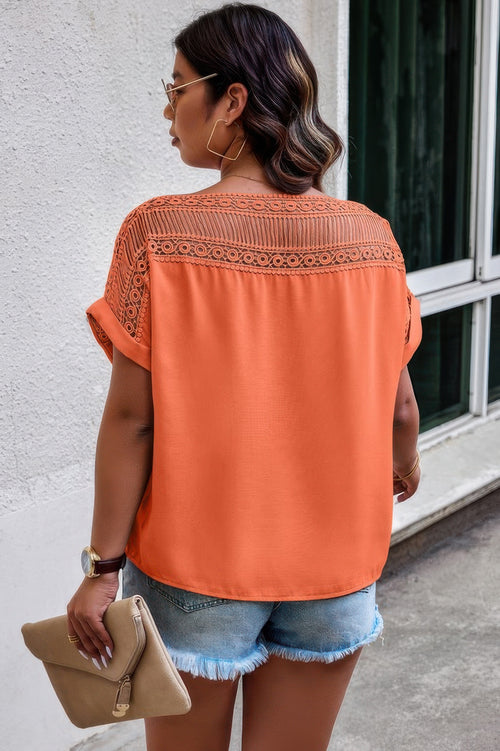 Back view of blouse showing full lace design in vibrant orange with relaxed silhouette