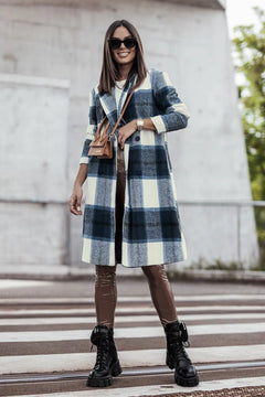 Woman wearing a plaid coat and brown boots on a city street.