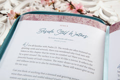 Open book with text and decorative cover on a floral background