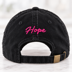 Black distressed baseball cap with frayed hot pink breast cancer awareness ribbon on front