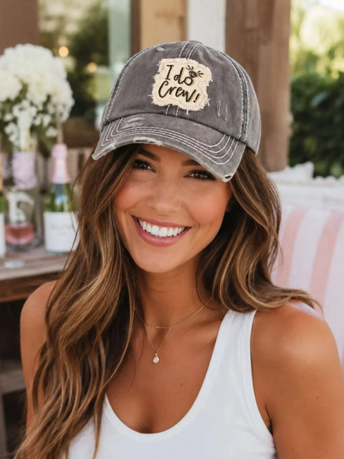 Woman wearing a gray I Do Crew distressed baseball cap