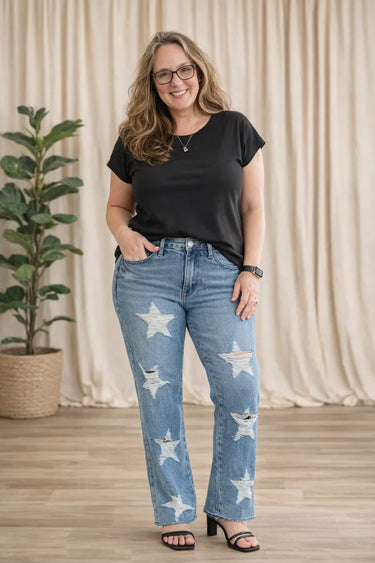 BeYOUtifully Comfortable founder Rita wearing a soft black Zenana stone washed tee and stretchy star-patterned Judy Blue distressed jeans.