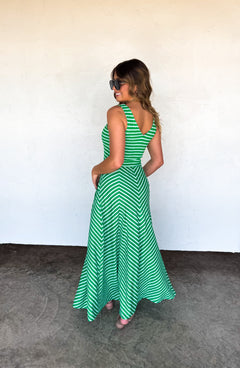 Woman wearing a green and white striped dress against a plain background