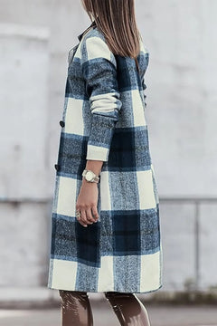 Person wearing a blue and white plaid coat with a blurred background