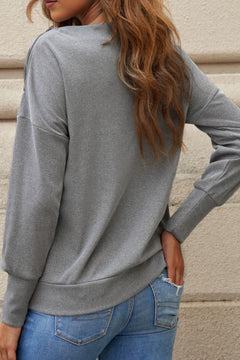 Chic single shoulder long sleeve sweatshirt in gray with zipper detail, back view shown on model styled with jeans. Trendy women’s pullover for casual wear.