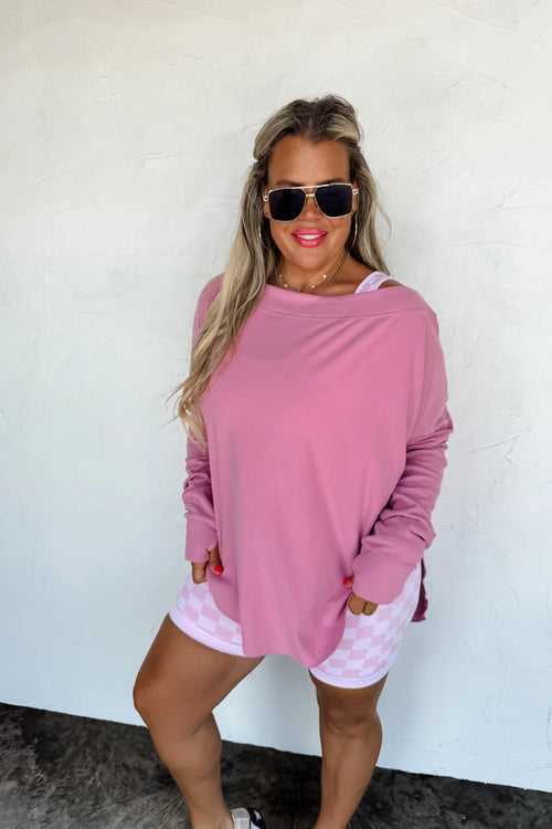 Mauvy pink athleisure top styled off the shoulder with casual shorts.