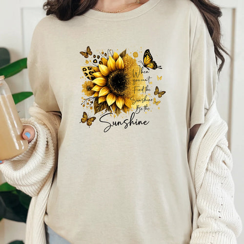 Natural graphic tee with gold sunflower design and “Be the Sunshine” inspirational message