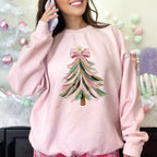 Person wearing a pink sweatshirt with a Christmas tree design in a festive setting.