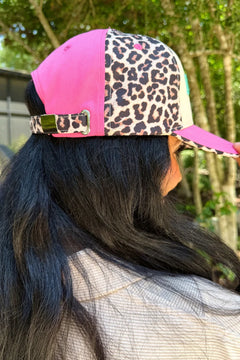 Person wearing a pink and leopard print cap outdoors