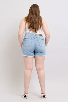  Back view of plus-size raw hem denim shorts, displaying flattering fit and coverage.