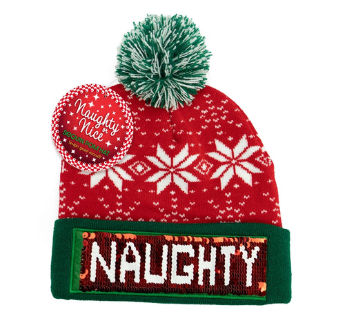 Red holiday pom hat with green brim and sequins reading “NAUGHTY.”
