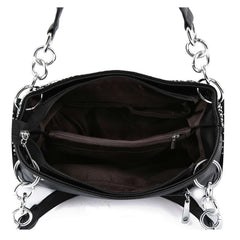Top view of the inside of a black handbag showing a center zip divider, interior pockets, and brown lining.