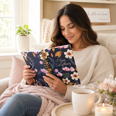 Woman reading a book titled 'A Time for Everything' on a couch with a cup of coffee and flowers.
