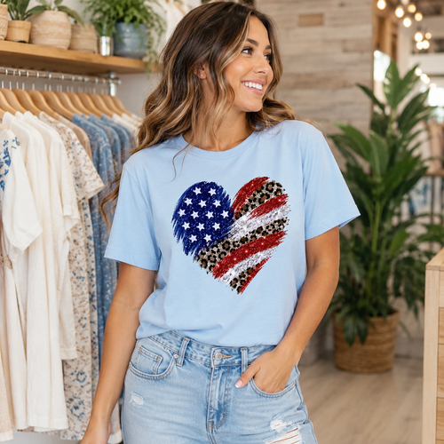 Baby blue Flag Heart Graphic Tee with glitter-style patriotic heart design and leopard print stripes on model.