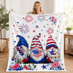 Woman holding up a patriotic gnome blanket featuring red white and blue gnomes, fireworks, stars, and floral accents.