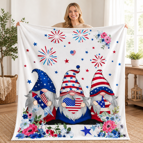 Woman holding up a patriotic gnome blanket featuring red white and blue gnomes, fireworks, stars, and floral accents.