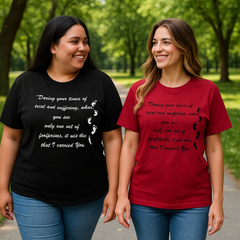 Two people wearing black and red t-shirts with text in a park.