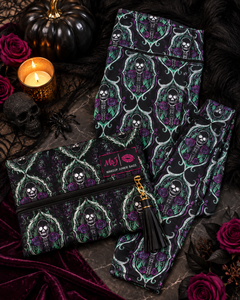 A gothic-themed clothing set featuring a black and purple skeleton rose pattern, styled in a Halloween flat-lay with a matching zip pouch, black tassel zipper pull, and a pink 'My J' brand label.
