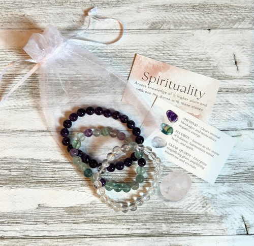 Set of beaded bracelets with a card on a wooden surface
