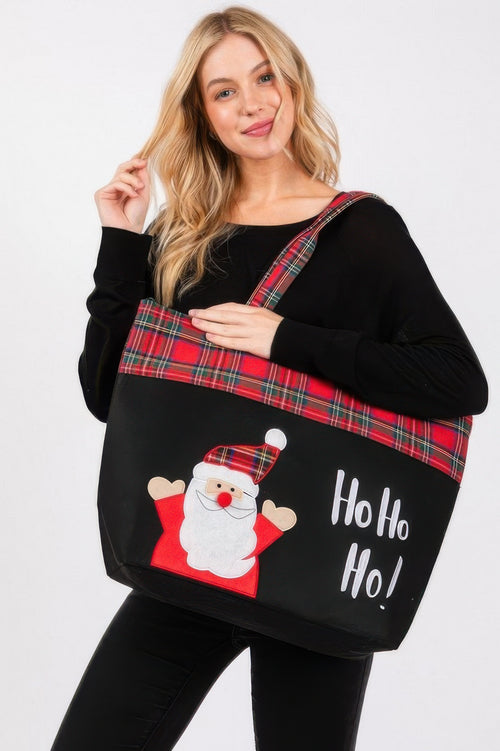 Blonde woman modeling a large red plaid Christmas tote bag with a Santa and “Ho Ho Ho!” print