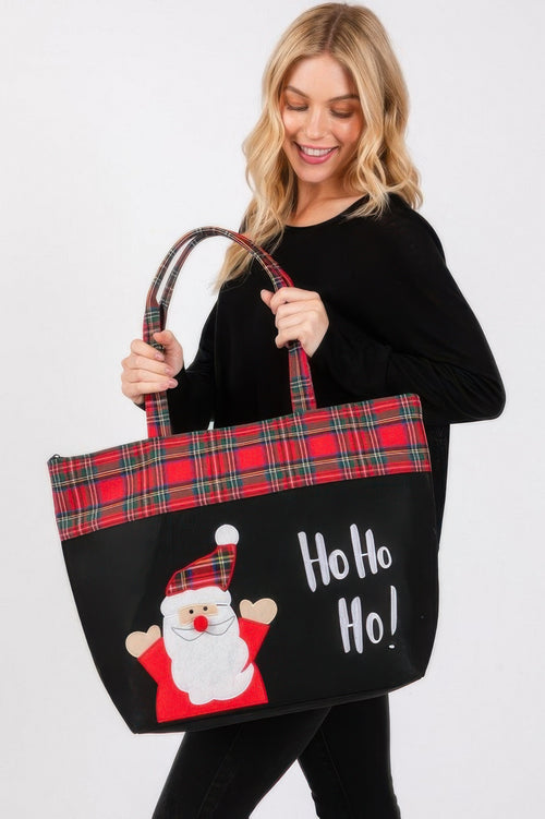 Blonde woman modeling a large red plaid Christmas tote bag with a Santa and “Ho Ho Ho!” print