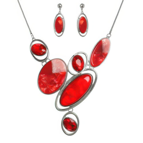 Jewelry set with red stones and silver accents on a white background