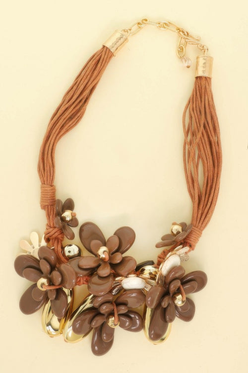 Necklace with brown floral beads and braided brown cord on a beige background