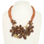 Stone Bloom Statement Necklace featuring marbled floral beads, floral charms, and multi-strand brown cords.
