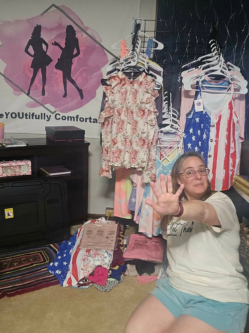 Boutique owner holding up five fingers to signal the $5 flash sale in front of a "BeYoutiful Comfort" logo and racks of clothing.