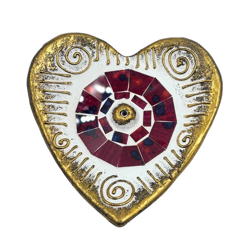 Decorative heart-shaped object with gold border and red and white center on a white background