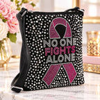 Breast cancer awareness rhinestone crossbody sling with pink ribbon and No One Fights Alone design