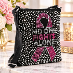 Breast cancer awareness rhinestone crossbody sling with pink ribbon and No One Fights Alone design