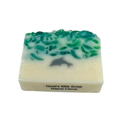 Bar of goats' milk soap with green top and white base on a white background