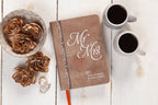 Book titled 'Mr & Mrs' 360 Devotionals For Busy Couples with coffee cups and flowers on a wooden surface