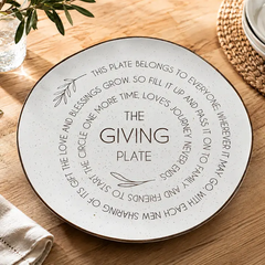 The Giving Plate 10.5 inch white speckled ceramic plate on a wooden table with sentimental pass-it-on inscription