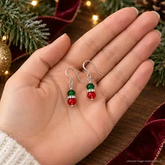 Red and green Christmas crystal earrings held in palm to show size